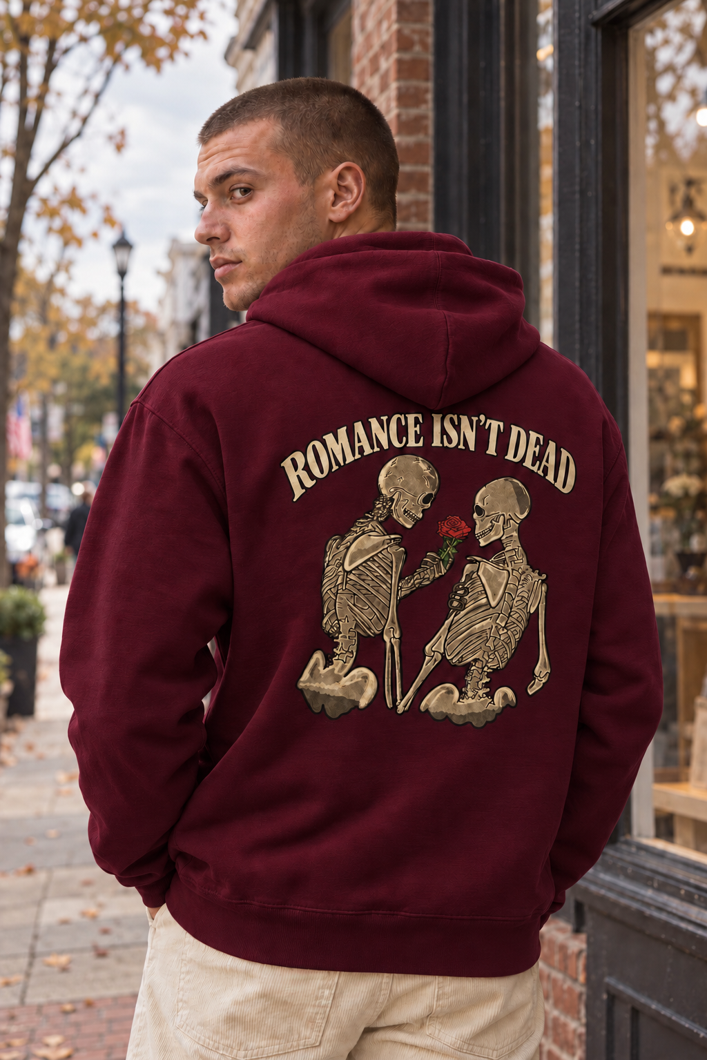Romance Isn't Dead Maroon hoodie, back print with two skeletons and a red rose